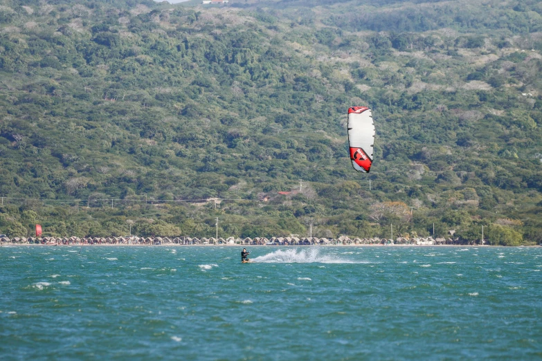 the parasailer is going down the water during the day