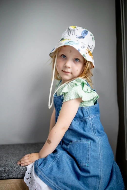 a little girl that is sitting down wearing a dress