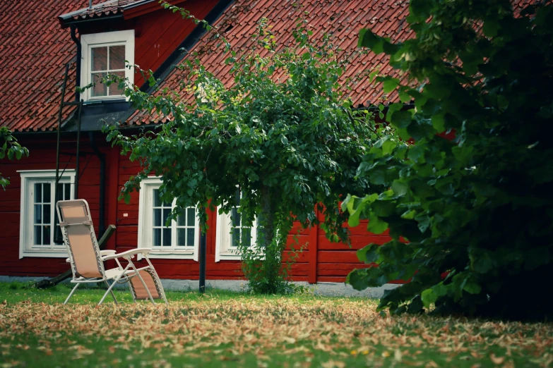 the lawn chair is on the grass outside the house