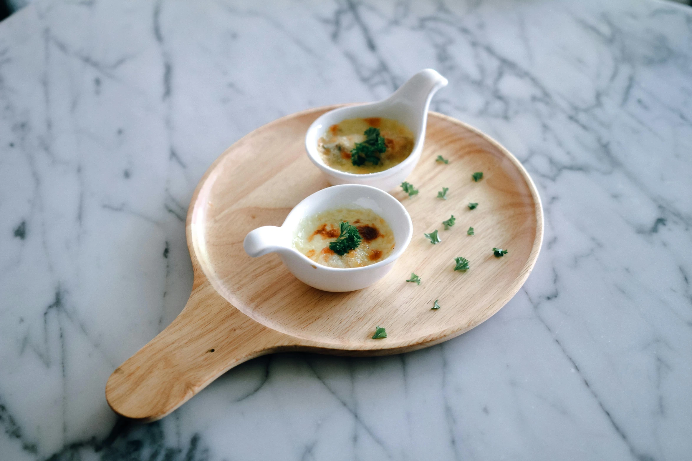 two cups of food sit on a marble tray