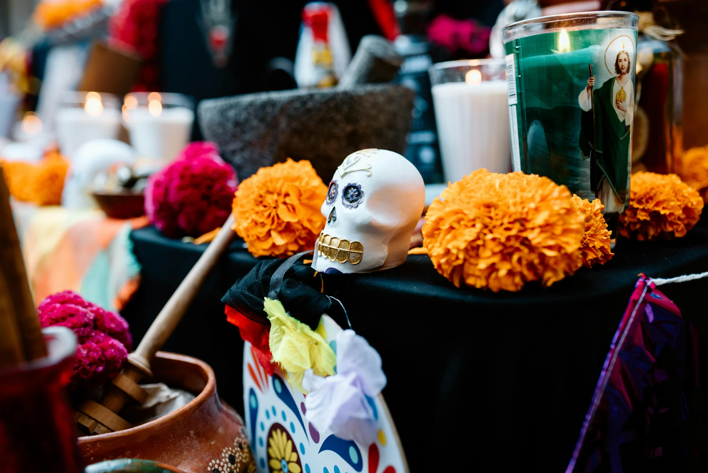 a table topped with a decorated skull and candles