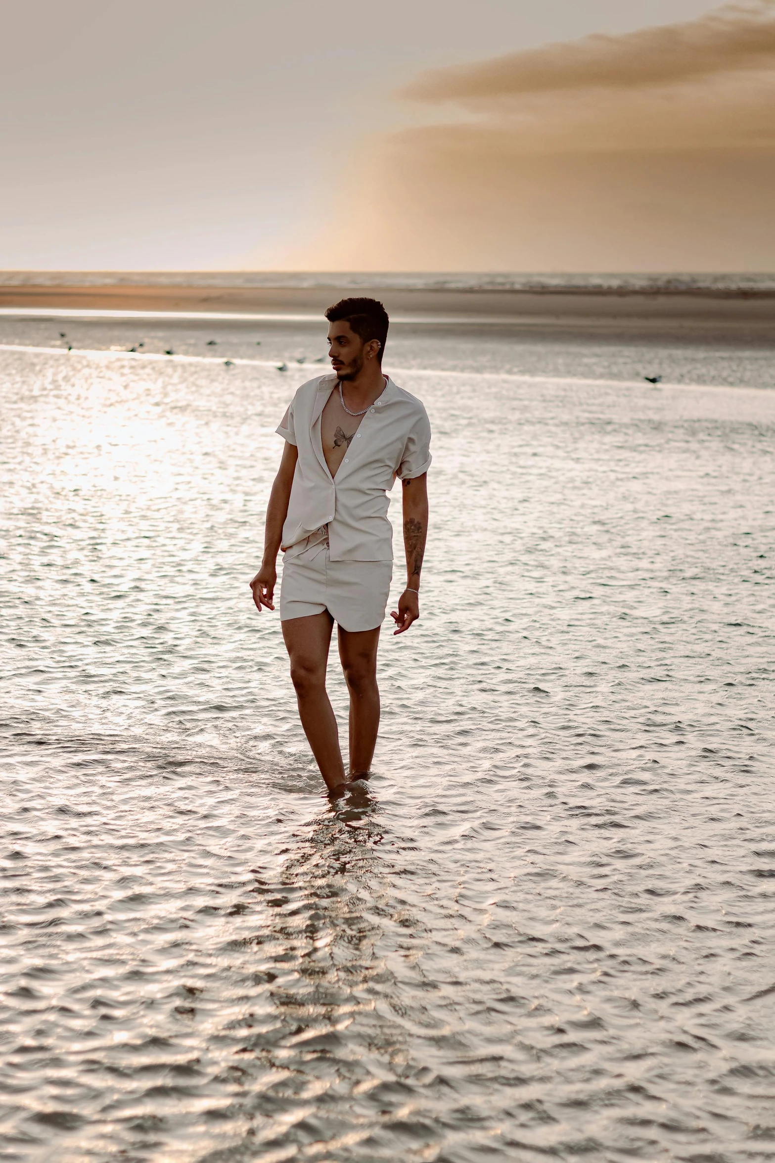 a man in white is walking in the water