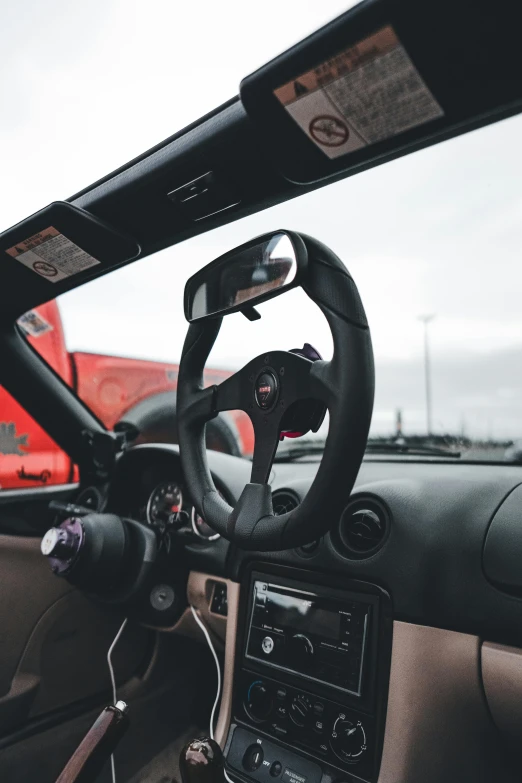 the interior of a car with steering wheel and dashboard controls