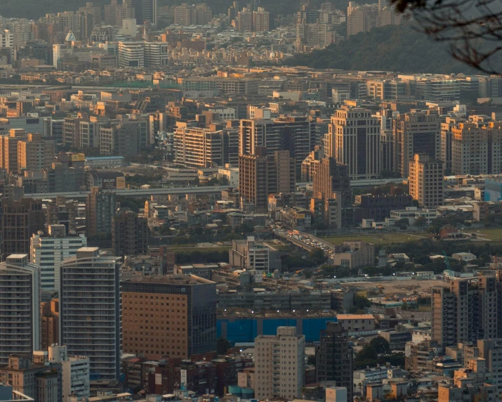 large city with yellow and gray buildings next to a mountain