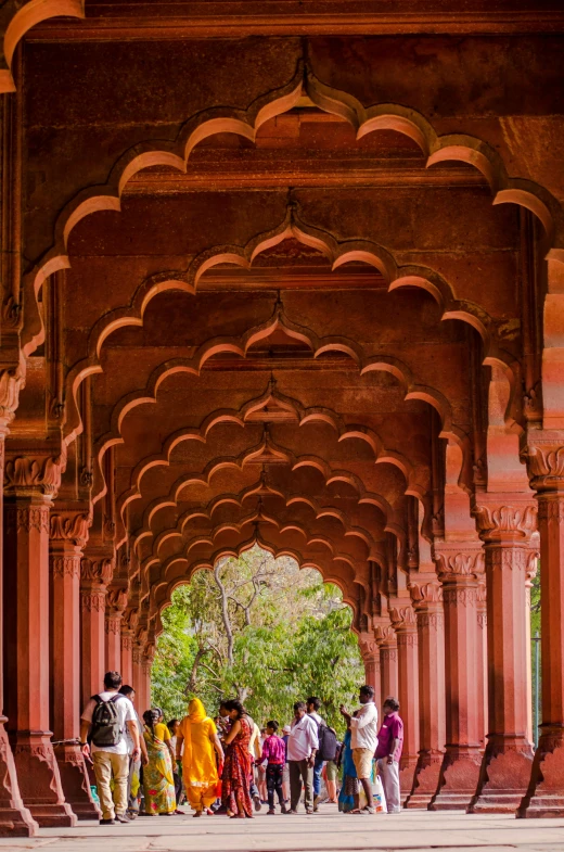 the men and women are walking under an arch