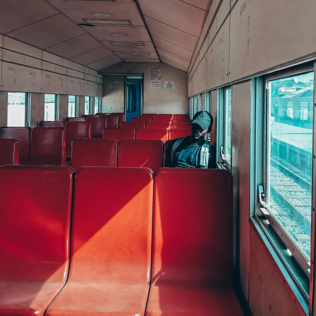 a room with multiple red seats looking out a window