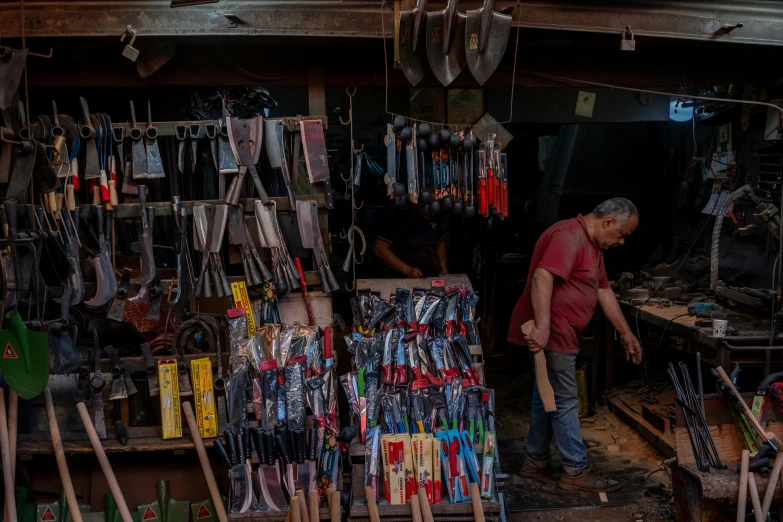 a man is standing next to a shelf with many items on it