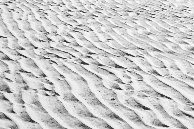 patterns in sand on the beach by a wave