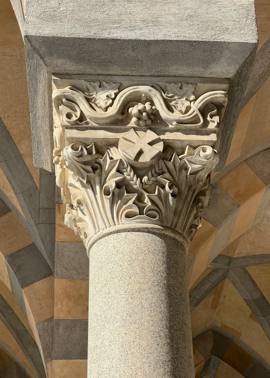an intricately carved column stands in front of tiled wall