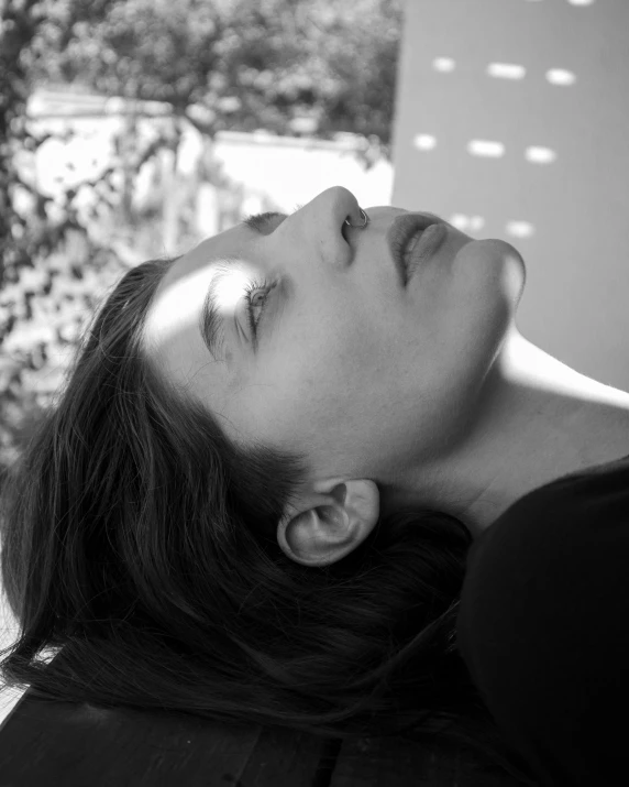 a woman laying down next to a tree