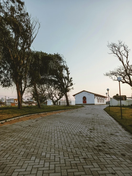 a brick road leading into a large white building