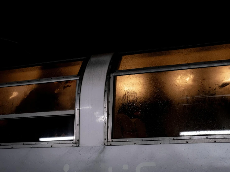 the window panes in a train that are almost completely covered with rain