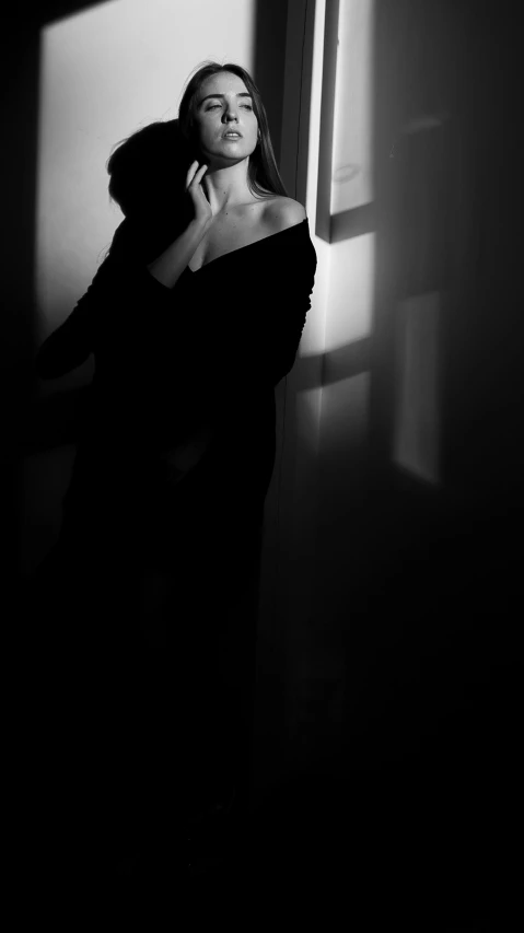 a woman with long hair standing in a dark room