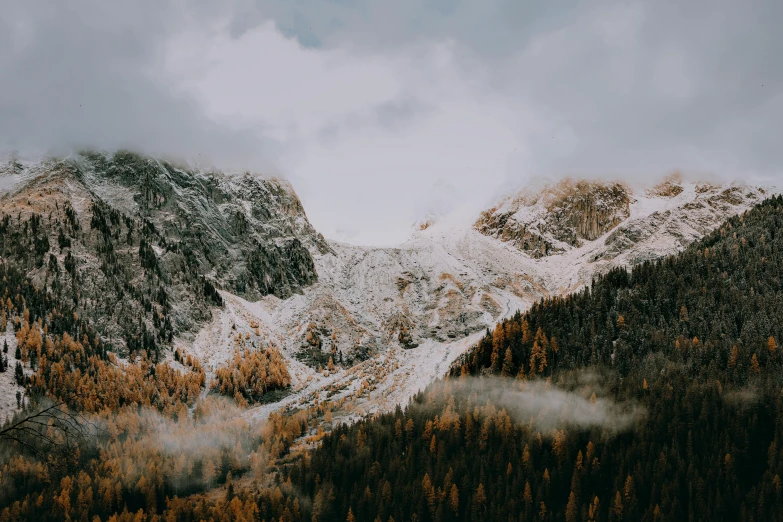 snowy mountain range under a cloudy sky