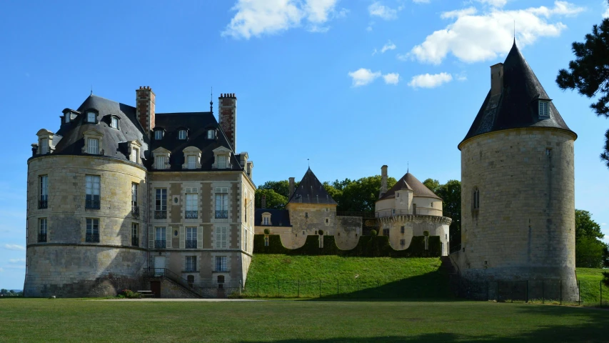 a big castle with three towers and grass