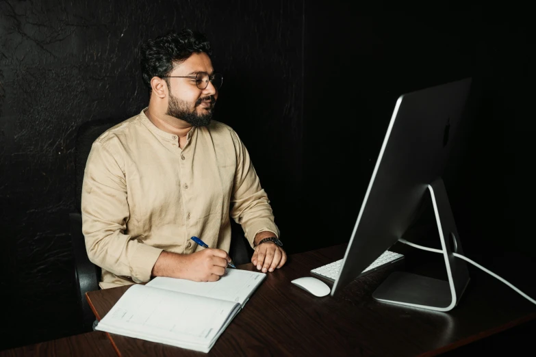 a man sitting at a desk looking into the screen