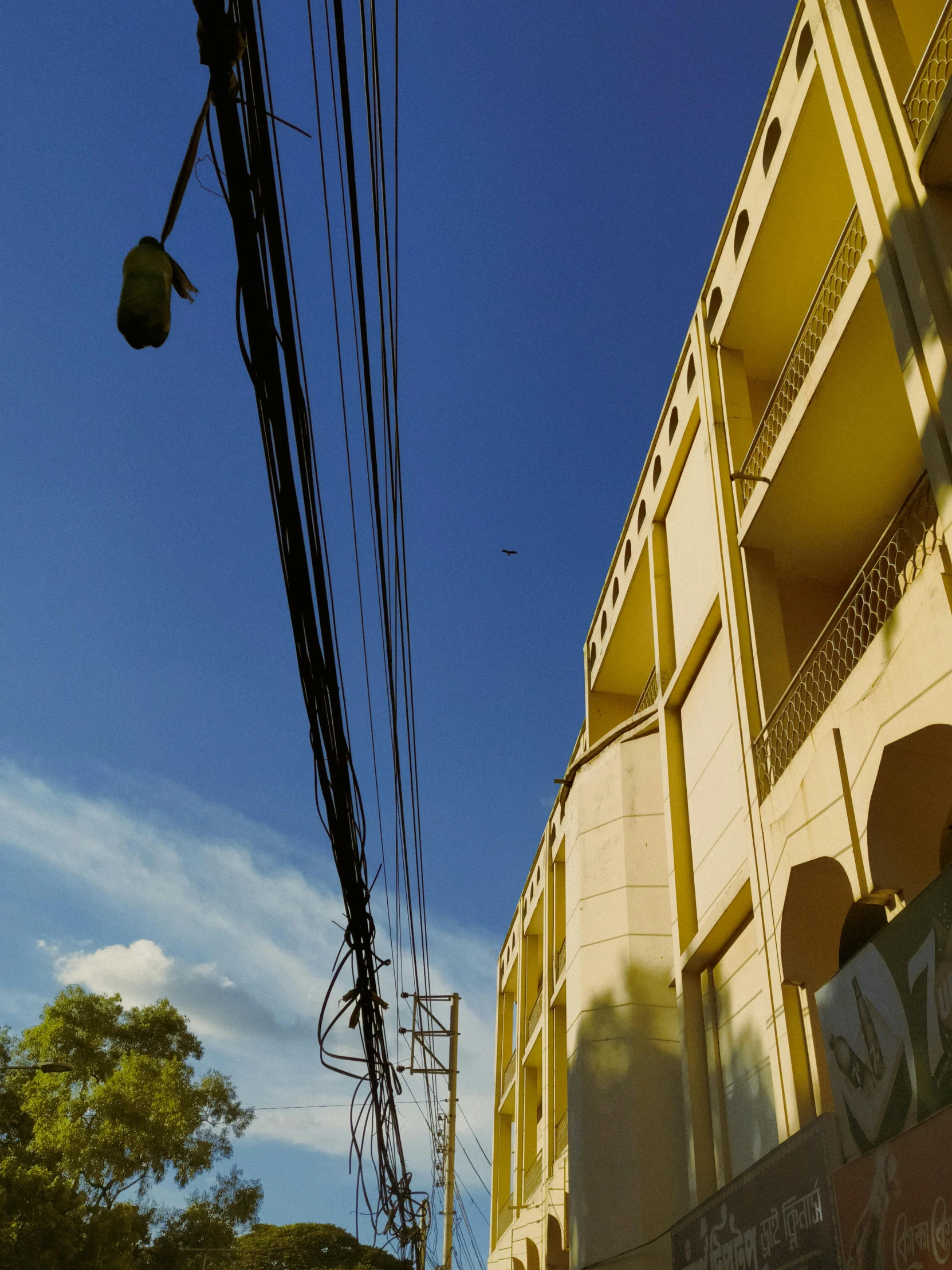 a large building under a blue sky and power lines