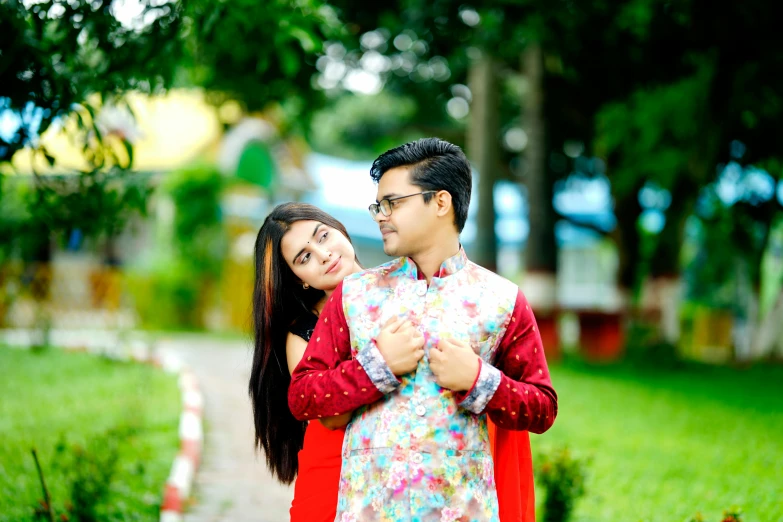 a young man and woman posing on the sidewalk together