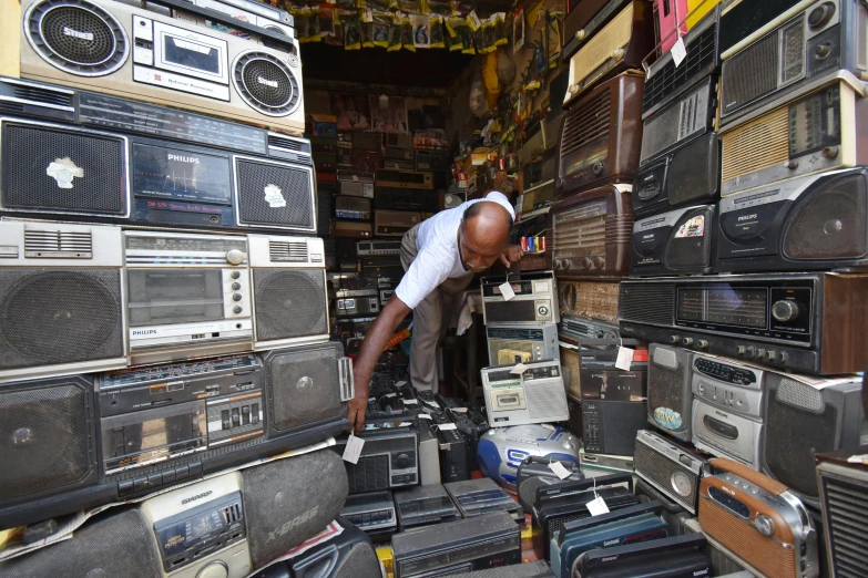 man browsing radio sets in the aisles of a room