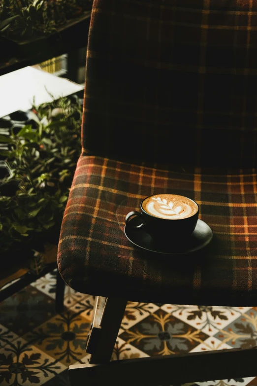 a coffee cup sitting on top of a wooden chair