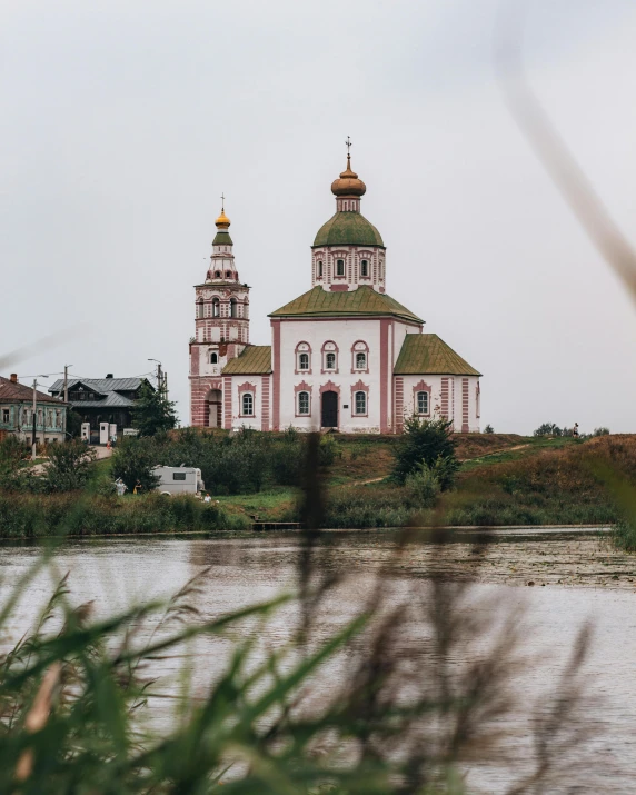 a large church with towers next to water