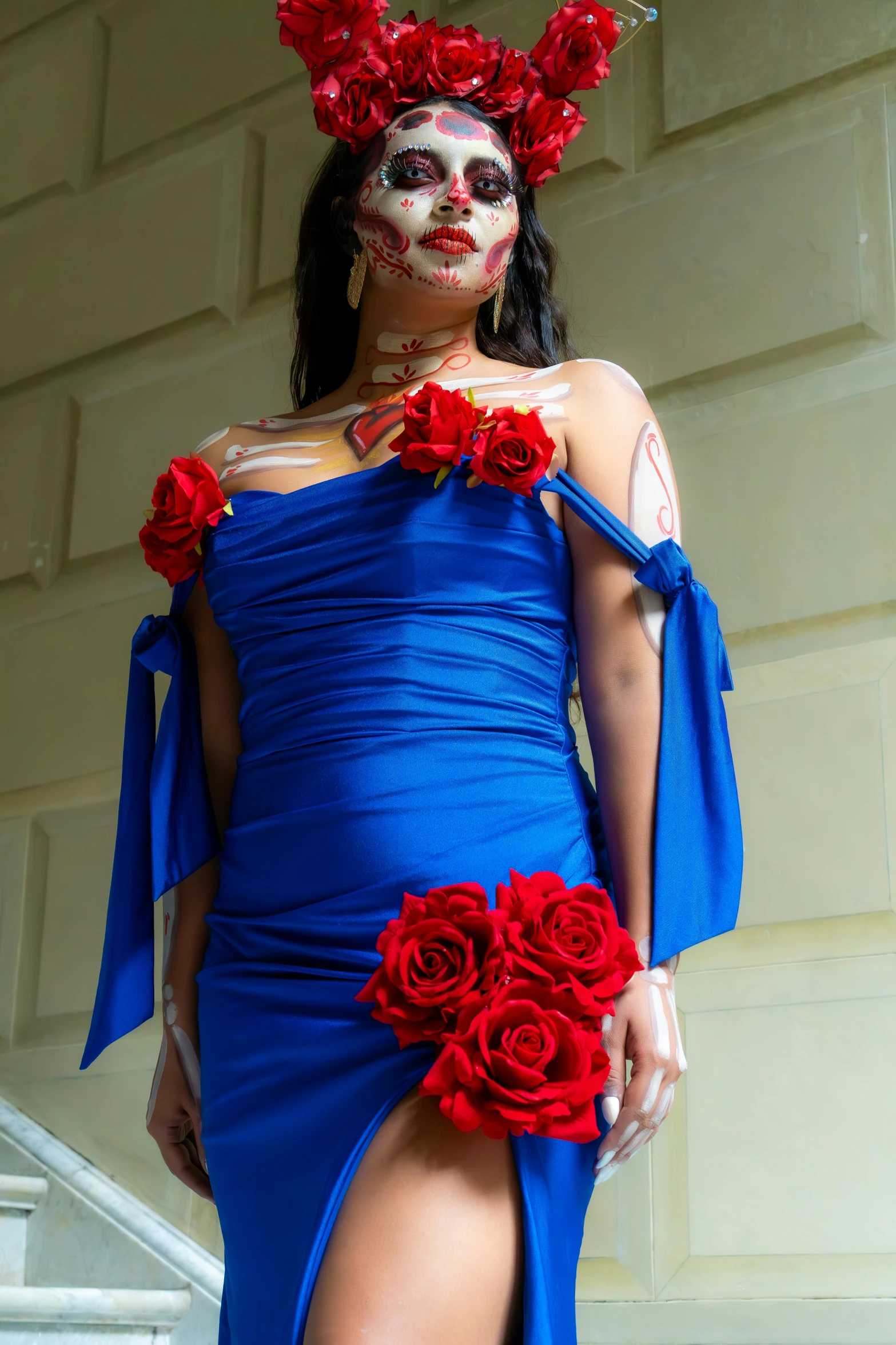 a beautiful woman with face paint is wearing a blue dress