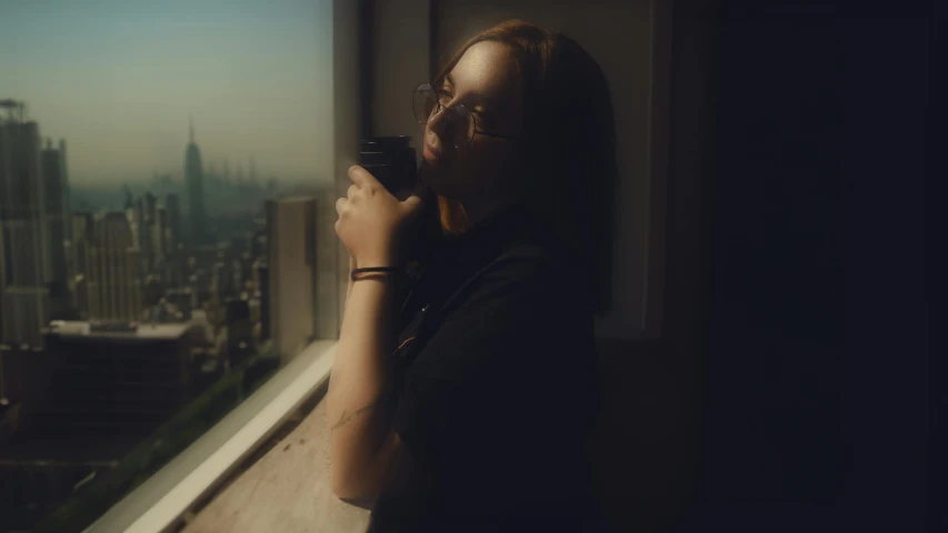 a person in a black shirt stands and looks at the city