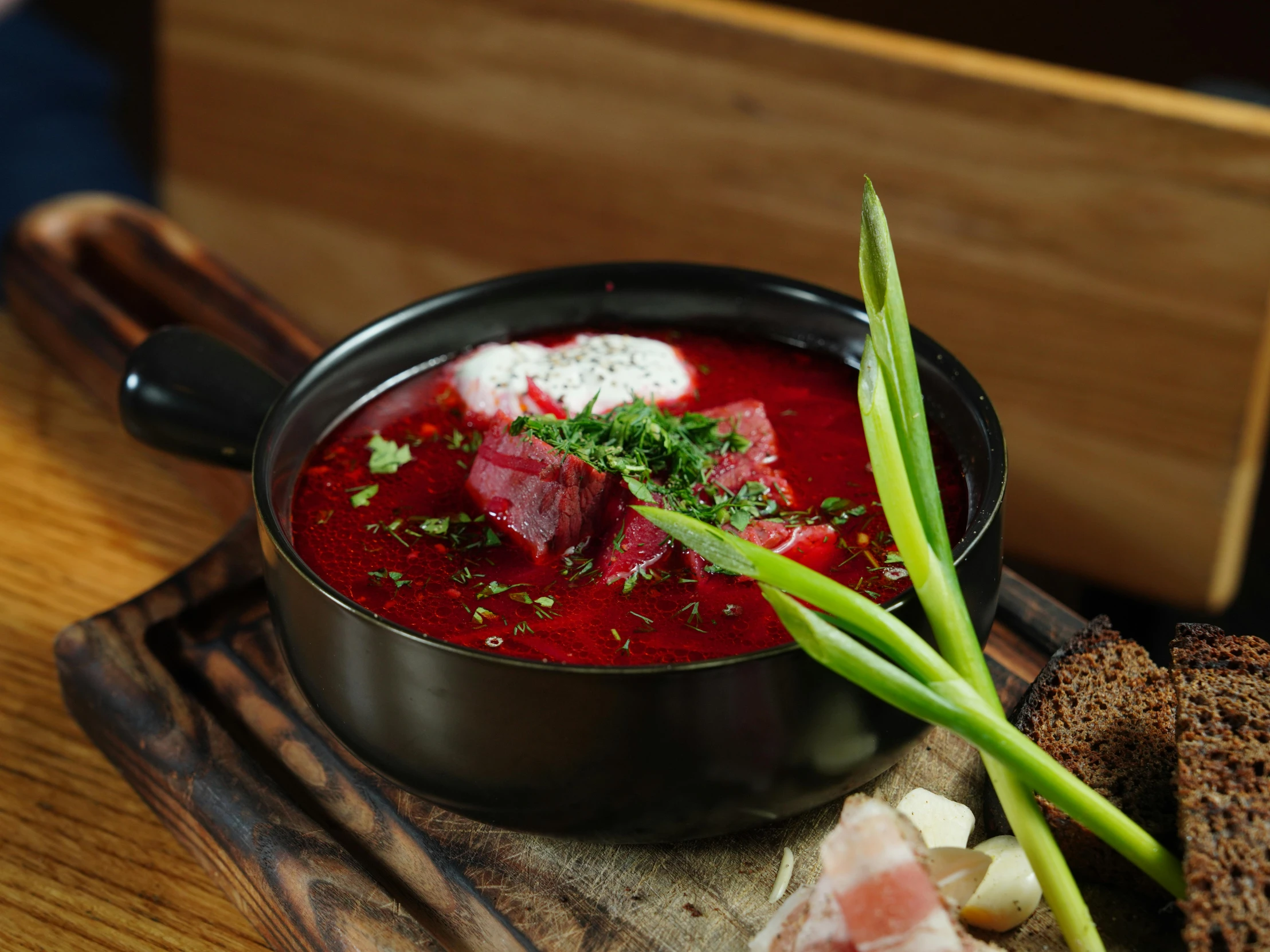 a bowl of soup and bread sit on a table