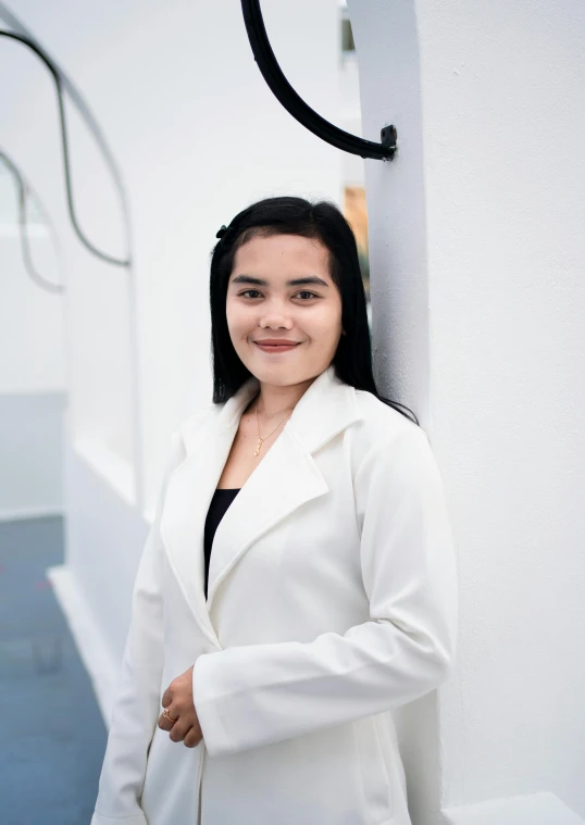 a woman is posing for a po while standing in front of a wall