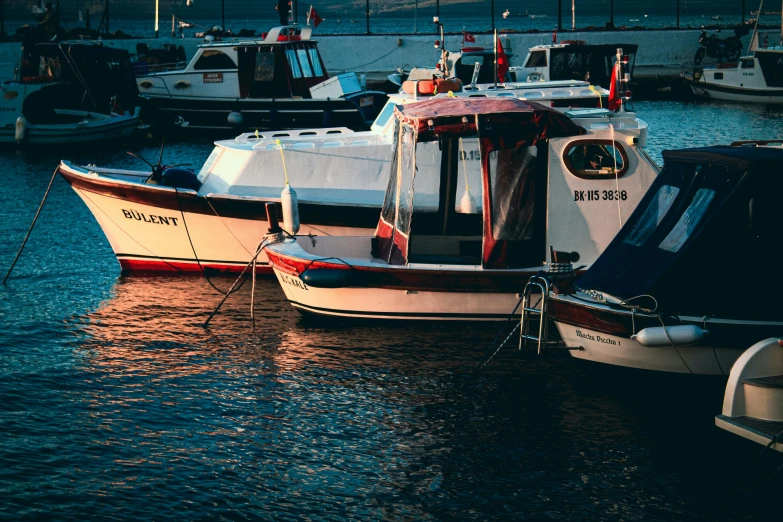 two boats sitting in the water in front of a dock