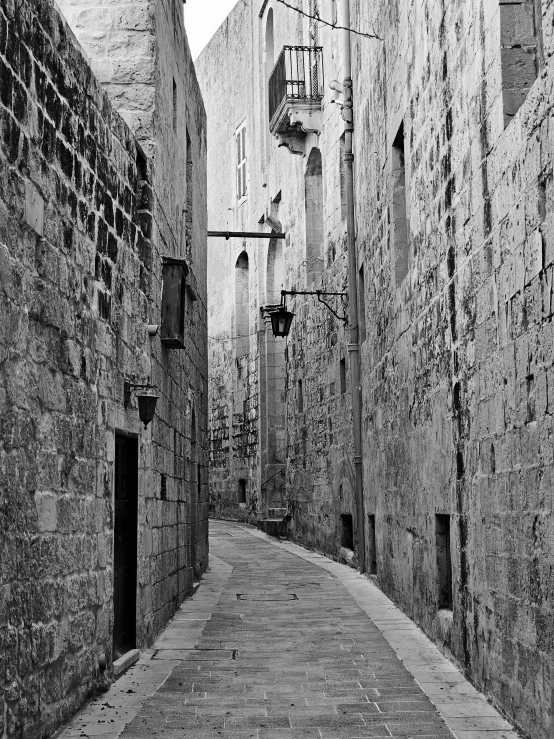 a street has a clock and a lamp on the side