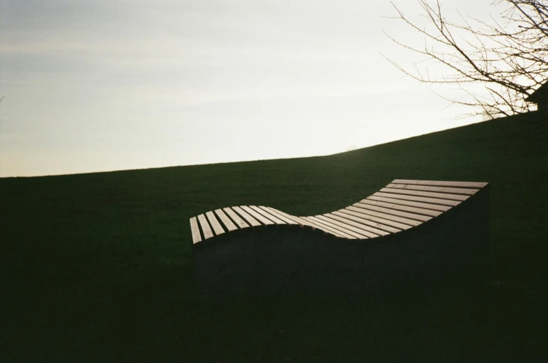 a bench sitting on top of a lush green field