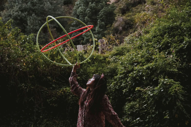 a person holding a metal ring above a green field