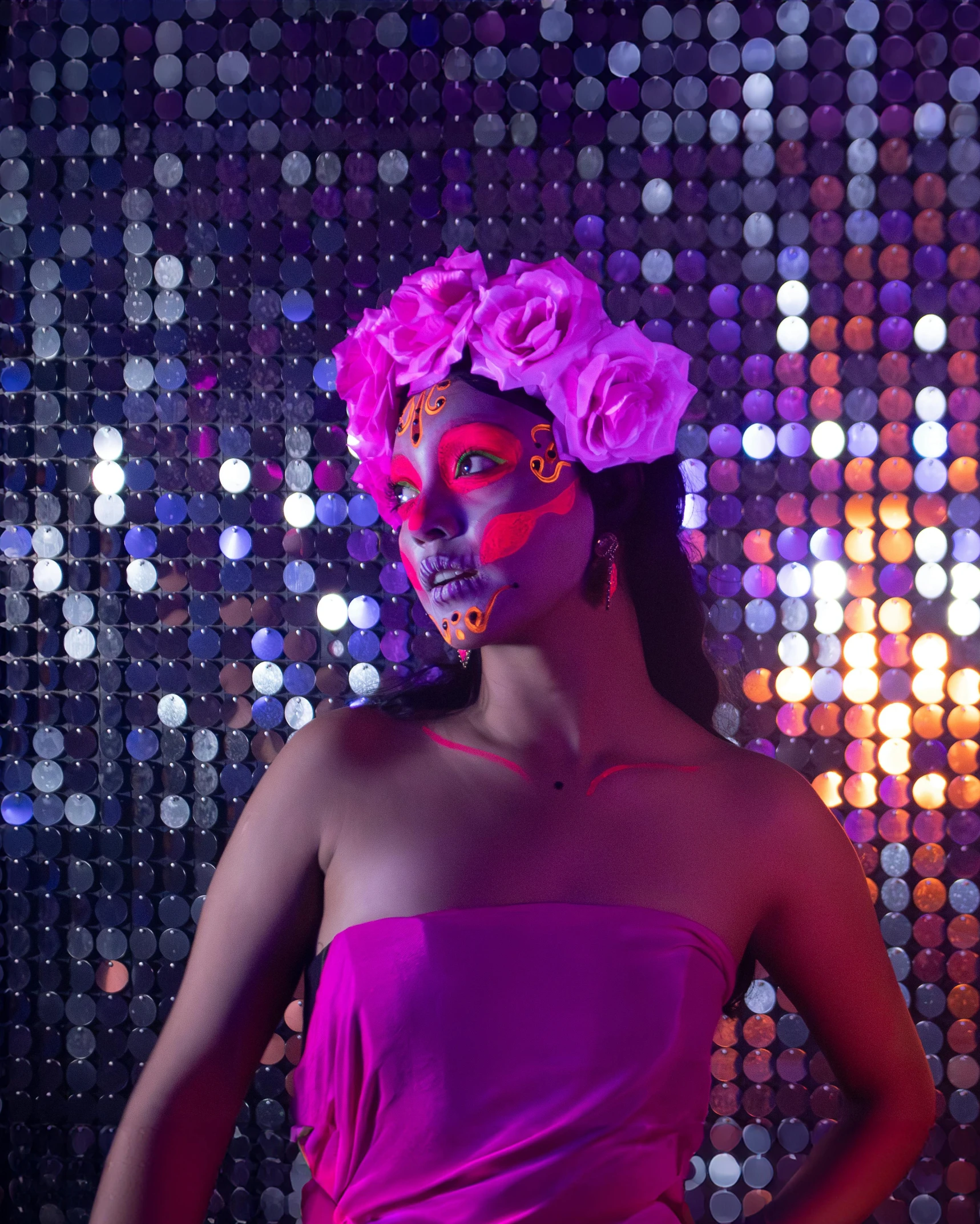 a girl wearing bright pink and orange face paint