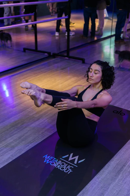 woman doing splits on a gym mat in a room