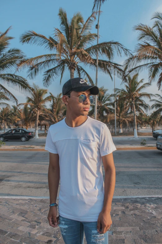 a young man in sunglasses and a white shirt