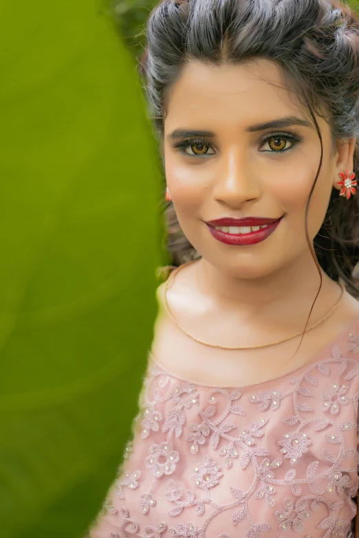 a woman with very long hair wearing a pink dress and earrings