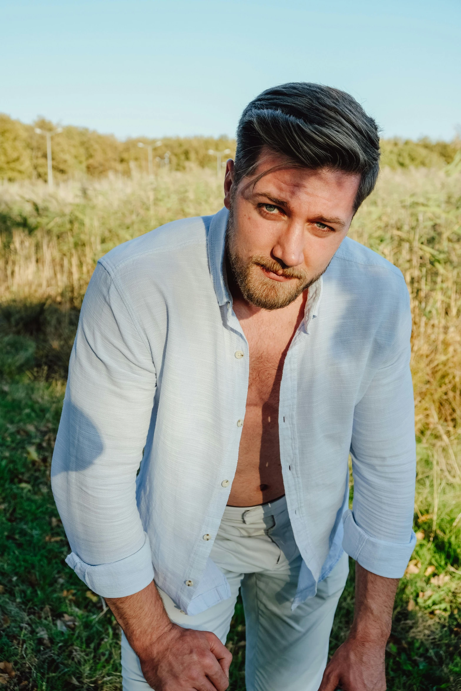 a man in white pants standing near grassy area