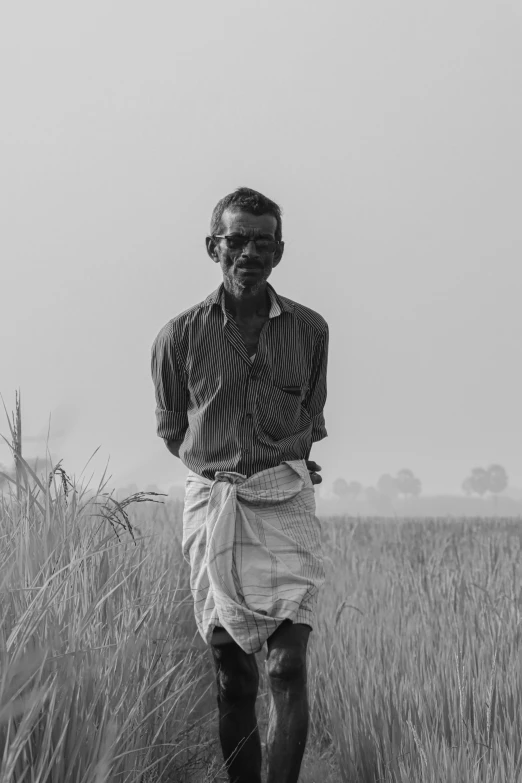 an old man is walking through the grass