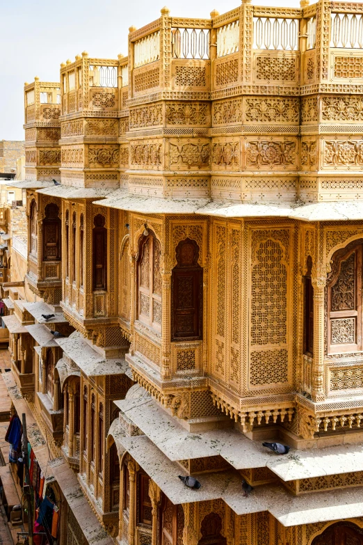 a building with gold tiles sitting in front of the sidewalk