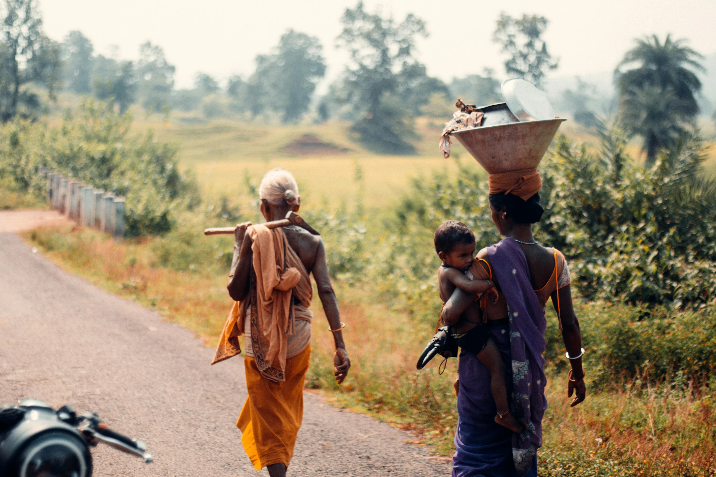 two people walk down the street carrying goods