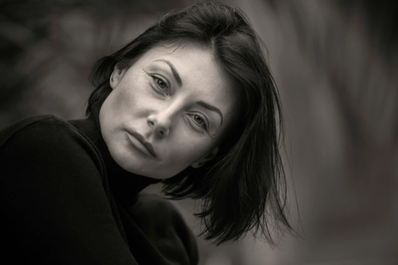 a young woman sitting with her hand on her shoulder