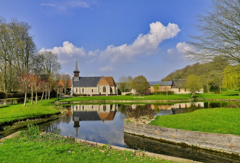 a pond with a church and water reflecting it