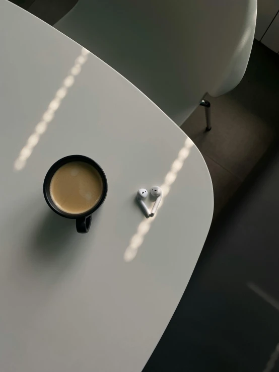 a coffee cup sits near the phone next to a desk