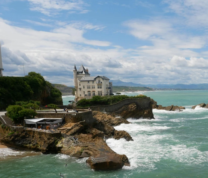 a view of a cliff in front of the water that is crashing