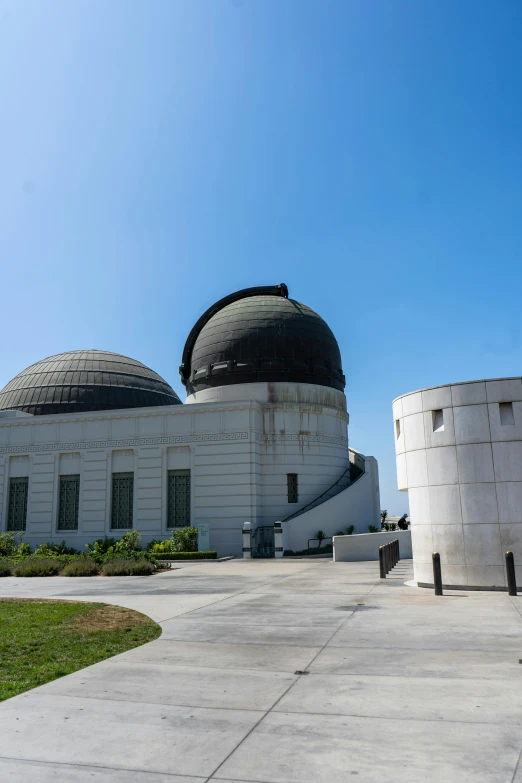 two large white buildings with round black roof