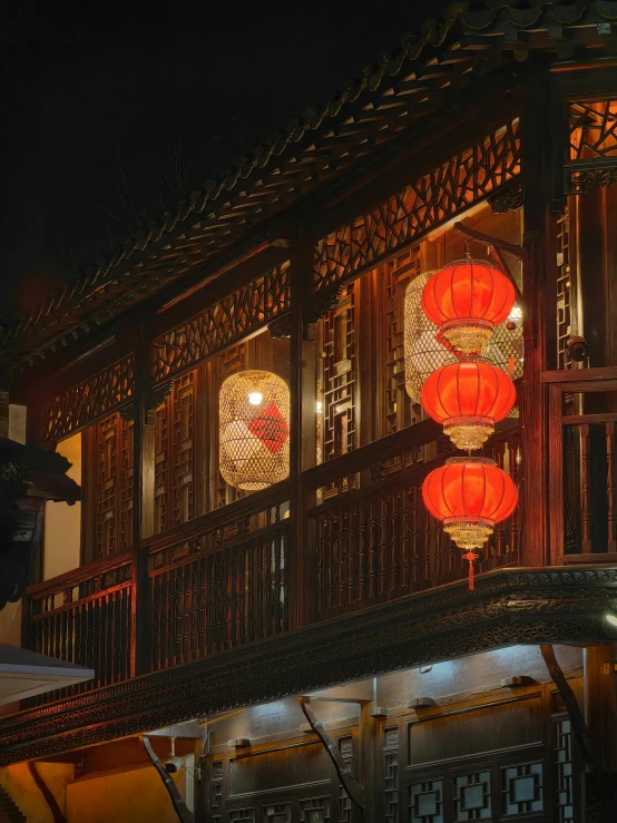 several lanterns in the shape of red glowing on a building
