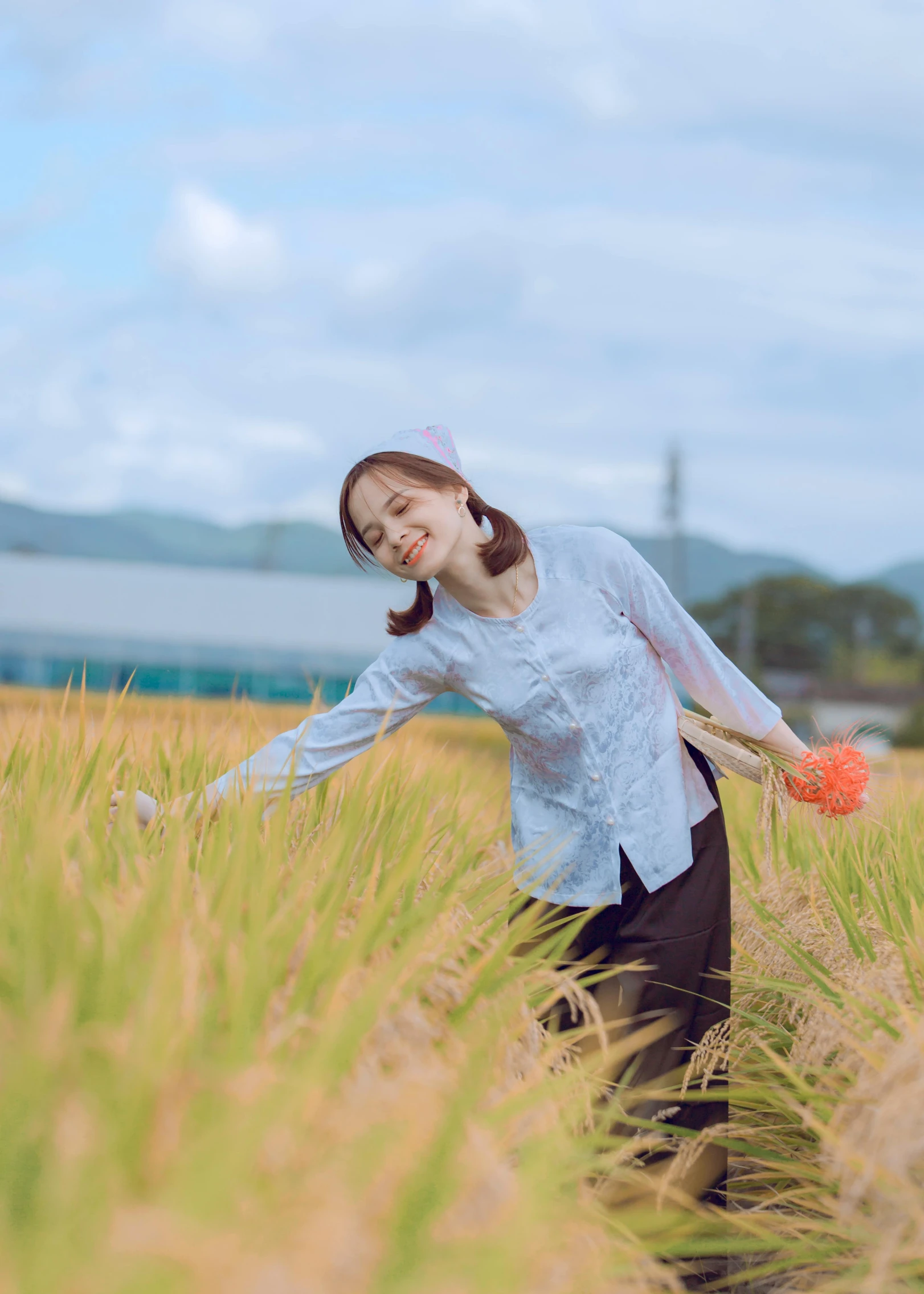 a girl walking in a field holding a bat and ball