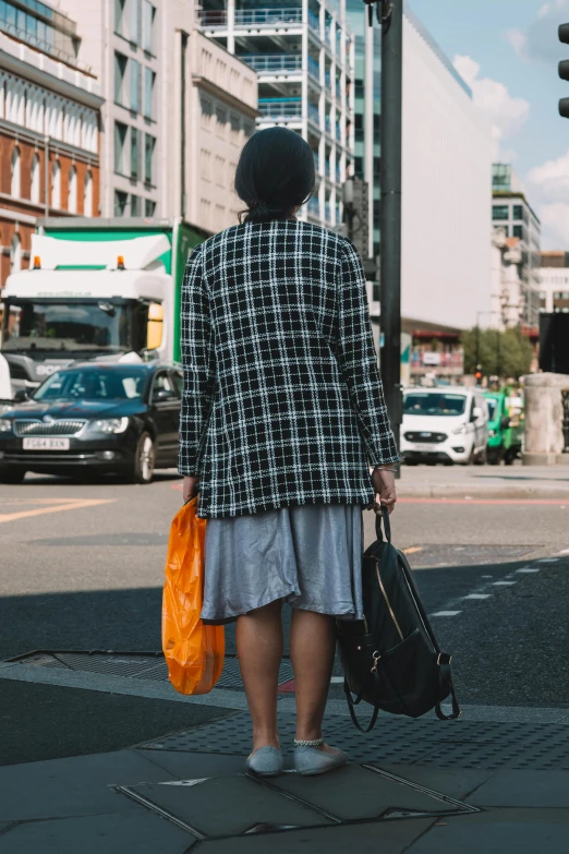 an old woman with two bags walking down the street