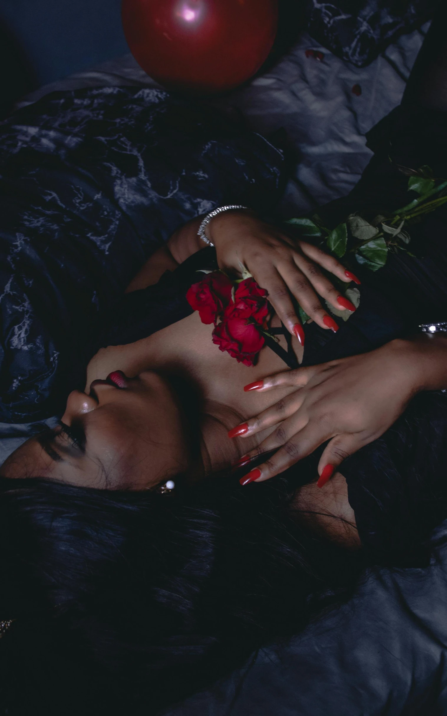 a woman with red nails and red roses on her chest